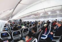 Airplane cabin with passengers seated in economy class