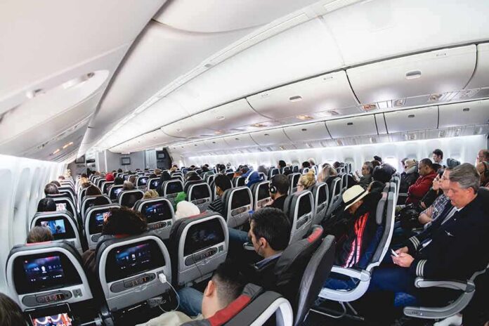 Airplane cabin with passengers seated in economy class
