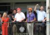 Eric Trump, Tucker Carlson, and Donald Trump Jr. on a balcony at a golf club event