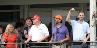 Eric Trump, Tucker Carlson, and Donald Trump Jr. on a balcony at a golf club event