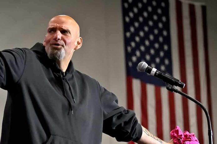 Bald man speaking at a microphone with a U.S. flag in the background