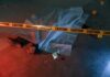 crime scene body under sheet behind caution tape