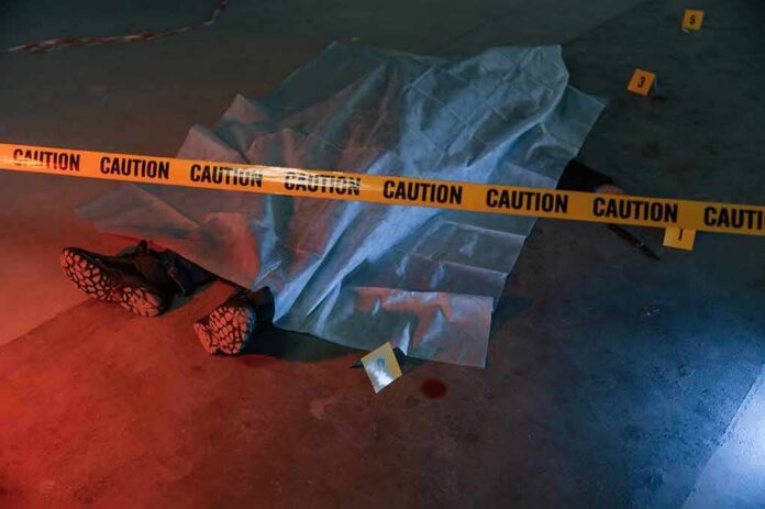crime scene body under sheet behind caution tape