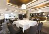 Interior of a modern restaurant with elegantly set tables and a bar area