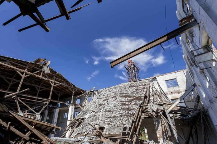 Collapsed industrial building with exposed beams under a blue sky