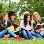2 Sudden Deaths Wreck College Campus Group of young women reading books on grass in a park