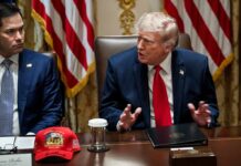Donald Trump speaks at a meeting beside Marco Rubio at a conference table