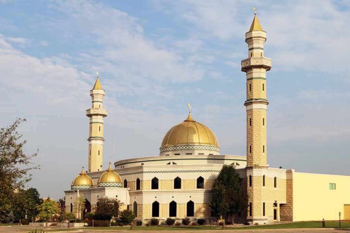 shutterstock_312777998 Mosque with golden dome and two tall minarets under a partly cloudy sky