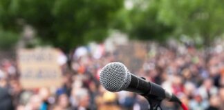 microphone on stand in front of a blurred crowd