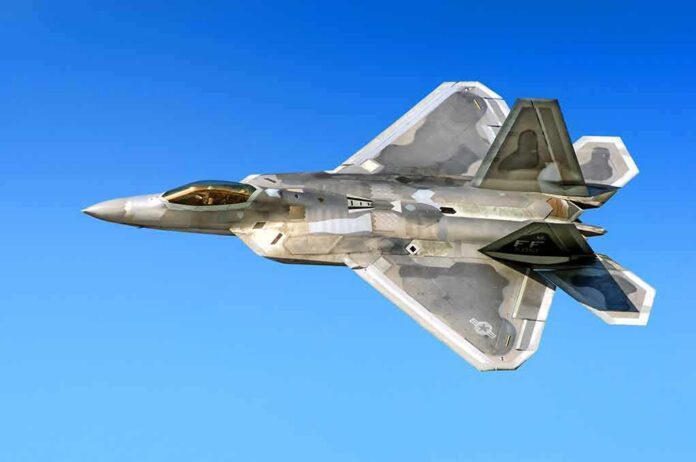 Stealth fighter jet in flight against a clear blue sky