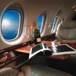 private jet cabin with leather seat, champagne and magazine on table