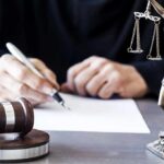 Digital Confession Rocks Kirk Murder Trial! Judge writing at desk with gavel and Lady Justice statue