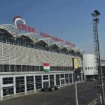 Trump Pulls ALL Troops Out Of Baghdad airport terminal exterior with modern facade and roadway