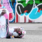 What Vandals Did To WWII Site is SICKENING spray paint cans on pavement in front of a graffiti wall