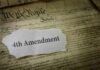 Fourth Amendment text on torn paper over the U.S. Constitution