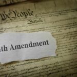 Fourth Amendment text on torn paper over the U.S. Constitution