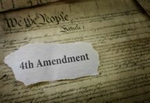 Fourth Amendment text on torn paper over the U.S. Constitution