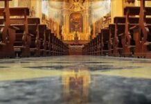 Priest Crushed By Crucifix Mid-Sermon Church interior with wooden pews facing ornate altar