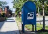 Powder Letters Rattles Capitol Hill Blue USPS mailbox on a suburban sidewalk