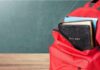 Catholic Priests Pushing Qur’an on Kids Red backpack with books on a classroom desk