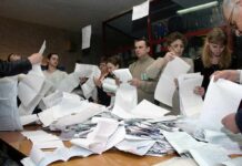 People counting ballots at a table