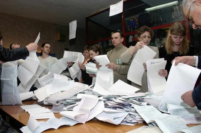 People counting ballots at a table