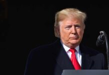 Judge Forces Trump To Sit For Deposition Donald Trump at a podium with a microphone