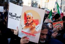 Protesters holding posters of Qasem Soleimani and Abu Mahdi al-Muhandis