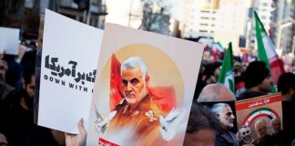 Protesters holding posters of Qasem Soleimani and Abu Mahdi al-Muhandis