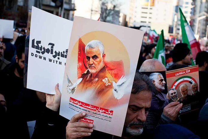 Protesters holding posters of Qasem Soleimani and Abu Mahdi al-Muhandis