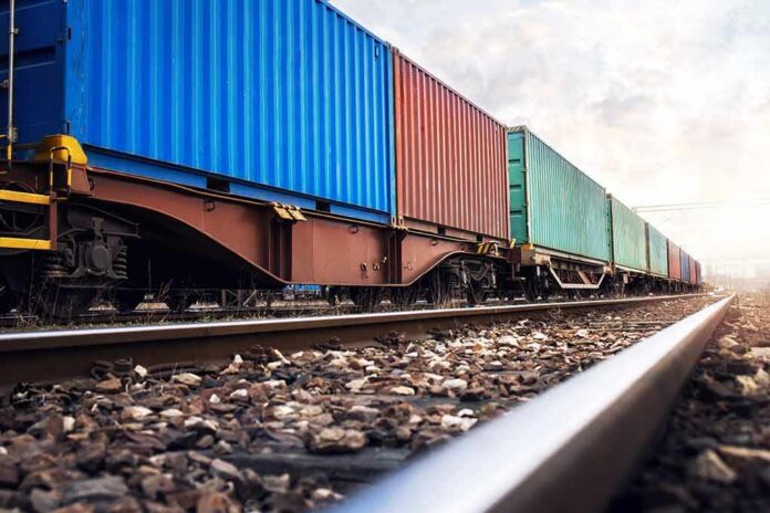 shutterstock_1660713808 Freight train with colorful shipping containers on railway tracks