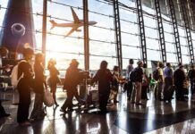 Airport Sting Nabs Alleged China Operative Passengers queue inside an airport terminal at sunset
