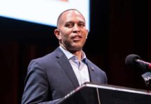 Congressman Vows to Return Deported Illegals Back to America Man in a suit speaking at a podium with a microphone
