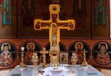 Orthodox church altar with large gilded cross and icons