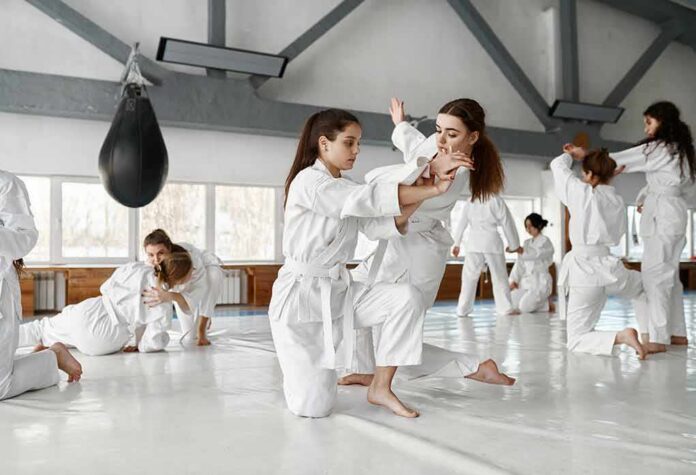 shutterstock_2292238137 martial arts students practicing grappling in a dojo