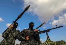 Armed militants in camouflage with rocket launchers and a machine gun
