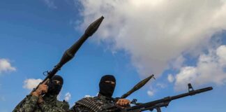 Armed militants in camouflage with rocket launchers and a machine gun