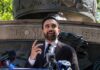 Zohran Mamdani speaking at an outdoor press conference