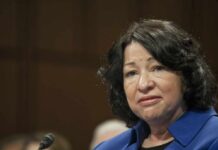 woman speaking at a hearing with a microphone visible