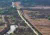 Russia’s Monster Radar Eyes ENTIRE Europe Border fence and patrol road cutting through dry landscape with sparse trees