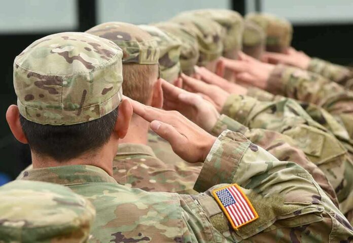 shutterstock_716351914 Soldiers in camouflage uniforms saluting in formation