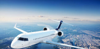 Airplane flying over a city with a river below.