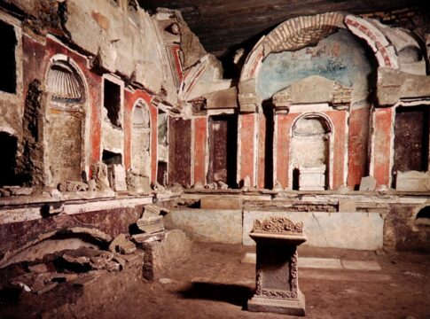 Interior view of an ancient burial chamber with frescoes and stone structures