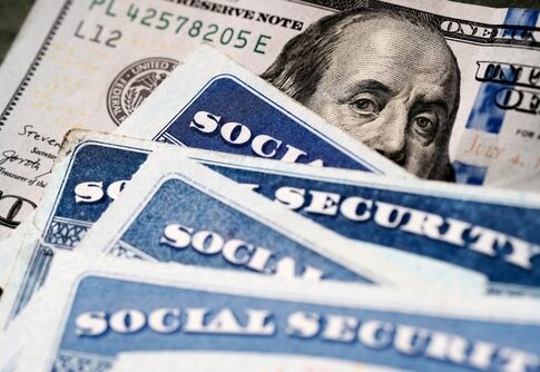Social security cards and a hundred dollar bill arranged together