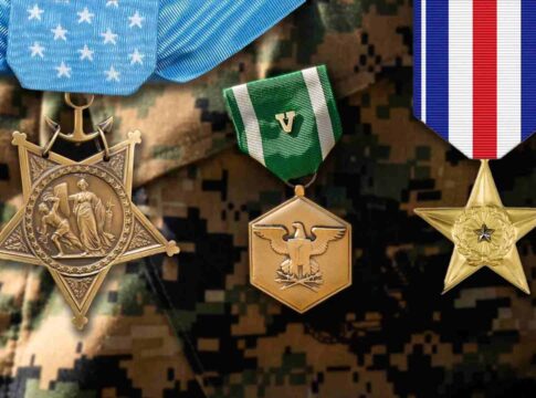 Three military medals displayed against a camouflage background