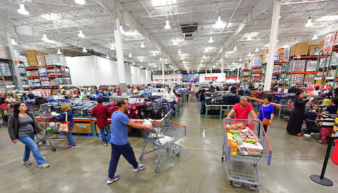 Busy warehouse store with customers shopping and pushing carts
