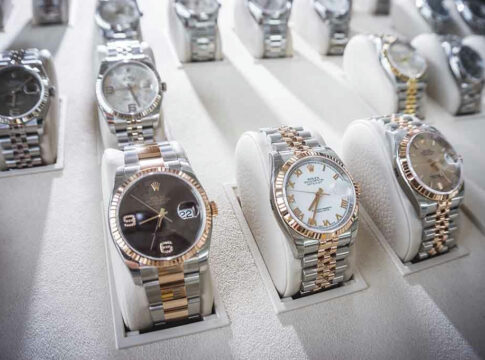 Display of luxury wristwatches on white stands.
