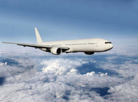Airplane flying above the clouds, blue sky background.