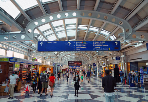 Busy airport terminal with travelers and directional signage