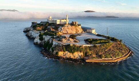 Aerial view of Alcatraz Island surrounded by water and fog